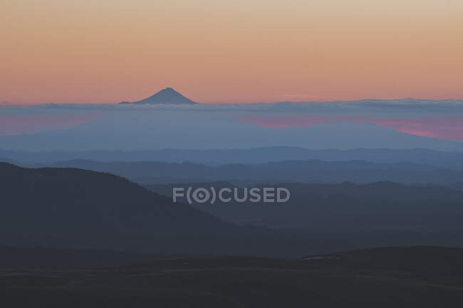 Monte Taranaki picco che sorge sopra le nuvole mentre il sole tramonta dietro l'orizzonte, Tongariro, Nuova Zelanda — Foto stock