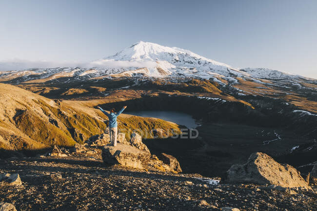 Young woman opening arms in celebration against Mt Ruapehu and Tama lakes, Tongariro, New Zealand — Stock Photo