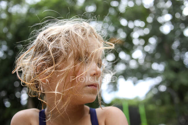 Close up of girl with messy hair outside looking off into the distance — Stock Photo