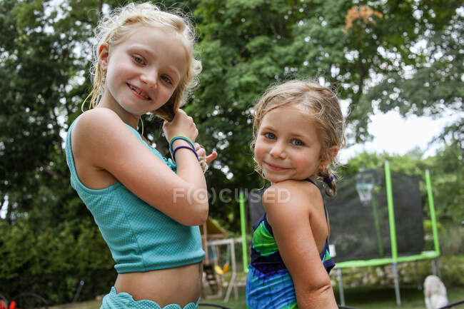 Porträt zweier Mädchen, die im Sommer zusammen im Hinterhof stehen — Stockfoto