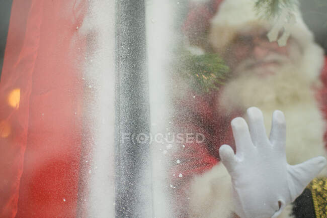 Санта протягивает руку, чтобы соединиться через окно — стоковое фото