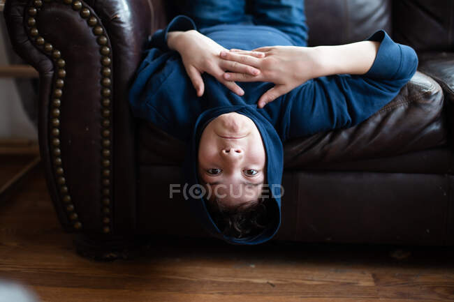 Tween boy upside down making funny face — Stock Photo