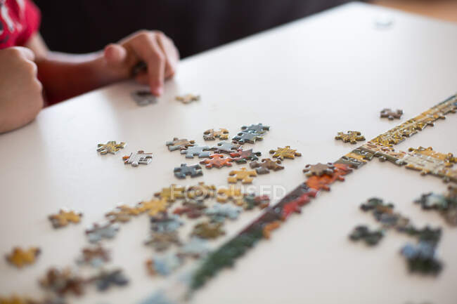 Nahaufnahme eines Kindes, das Puzzle zusammensetzt — Stockfoto