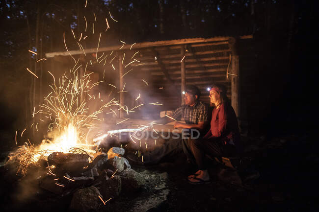 Funken steigen aus einem Lagerfeuer auf, während zwei Wanderer den Appalachian Trail beobachten. — Stockfoto