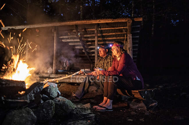 Casal desfrutar de calor da fogueira em Appalachian Trail lean to, Maine — Fotografia de Stock