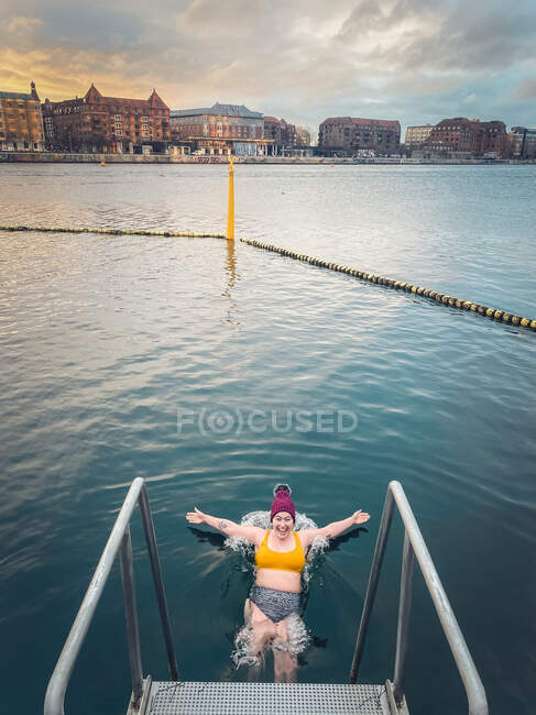 Anmutig fällt junge Frau bei Sonnenaufgang ins eiskalte Wasser Dänemark — Stockfoto