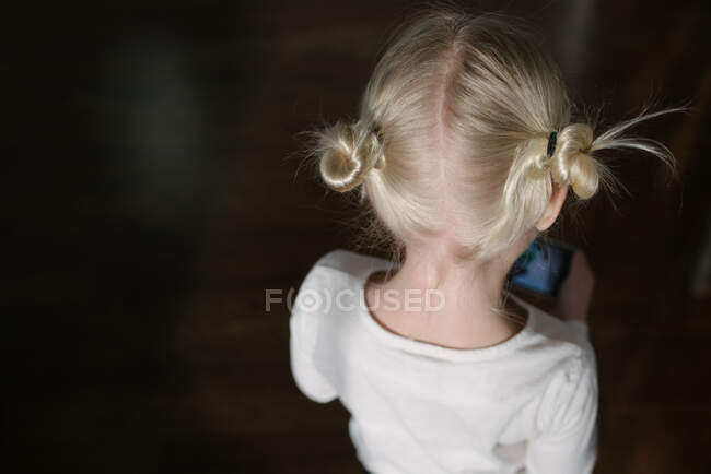Portrait of little girl's blonde hair buns from behind — Stock Photo