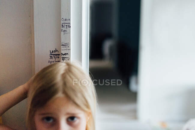 Measuring girl's height at home on door frame — Stock Photo