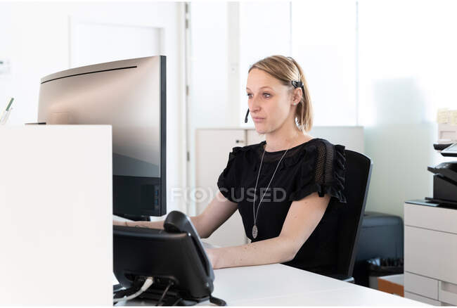 Une secrétaire médicale rédige un rapport sur son ordinateur — Photo de stock