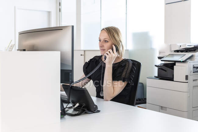 Eine medizinische Sekretärin nimmt das Telefon entgegen — Stockfoto