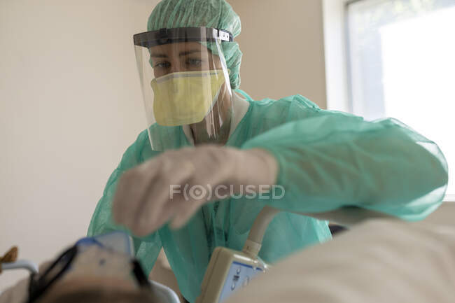 Enfermera cuida al paciente, protegido de covid-19 - foto de stock