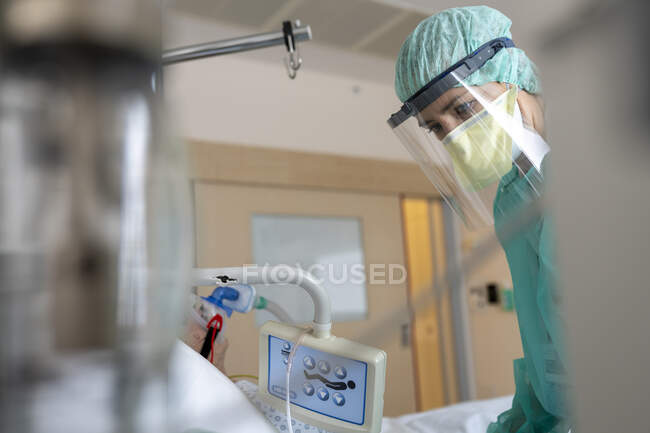 Медсестра доглядає за пацієнтом, захищеним від Конід-19 — стокове фото