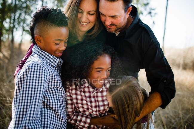 Family of Five Standing in Field Smiling & Hugging — Stock Photo