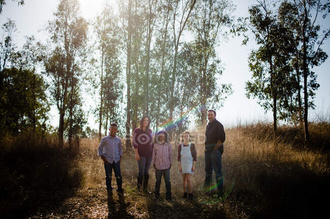 Семья из пяти человек, стоящих в полевой позе перед камерой — стоковое фото
