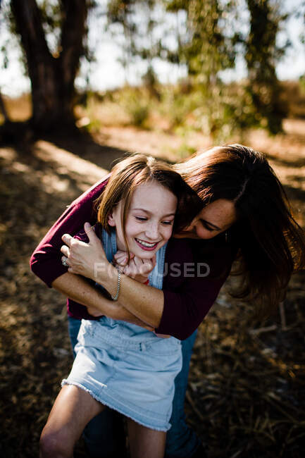 Madre che abbraccia la figlia ridente al parco di Chula Vista — Foto stock