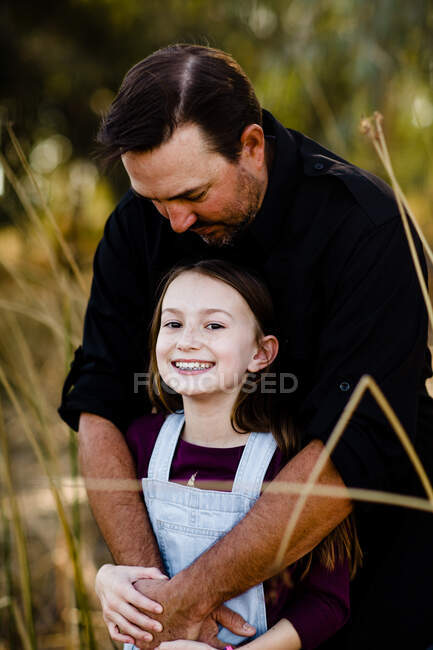 Тато цілує доньку на вершині голови в парку Чула-Віста. — стокове фото