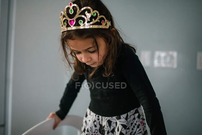 4 year old girl wearing tiara looking down — Stock Photo