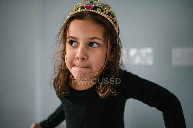 Petite fille portant une tiare avec une expression espiègle — Photo de stock