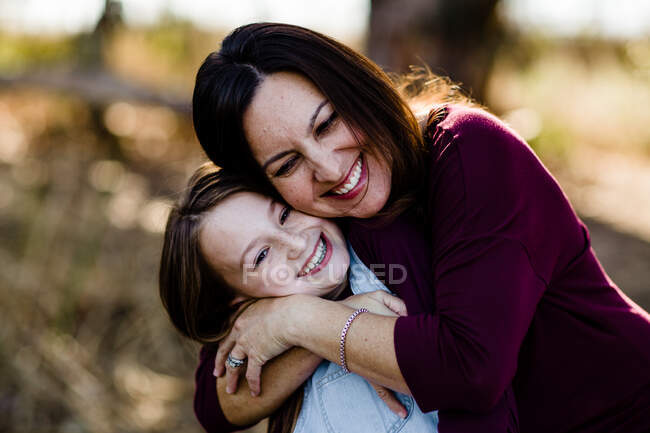 Madre e hija Abrazando y riendo en el parque en Chula Vista - foto de stock