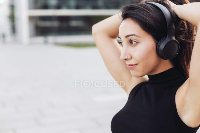 Close up retrato de uma jovem em fones de cabeça olhando para a distância — Fotografia de Stock