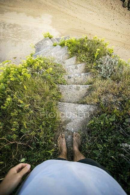 Barefoot boy on beach stairs — Stock Photo