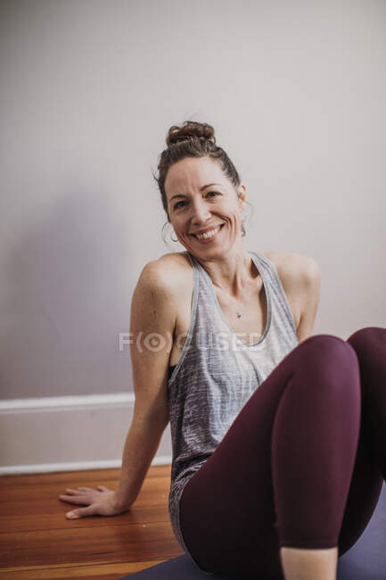 Крытый портрет улыбающейся спортсменки в йоге и спортивной одежде — стоковое фото