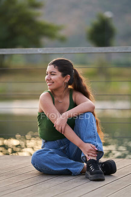 Красивая молодая женщина позирует перед камерой сзади на Америи — стоковое фото