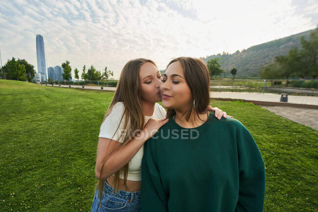 A picture of her friends kissing on the cheek — Stock Photo