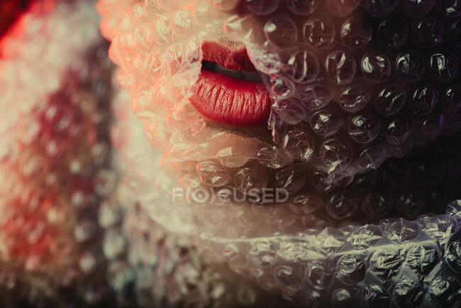 Macro red lips in bubble wrap. Awesome beautiful Girl. — Stock Photo