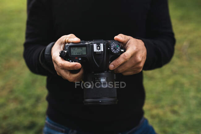 Tourné des mains d'un homme tenant une caméra — Photo de stock