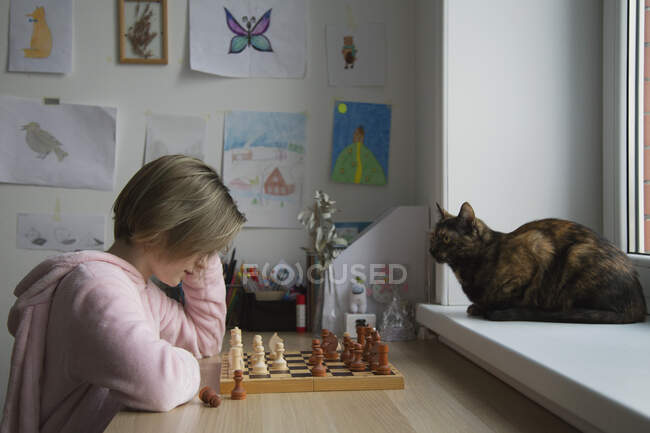 Uma menina joga um jogo de tabuleiro close-up. Xadrez.. — Fotografia de Stock