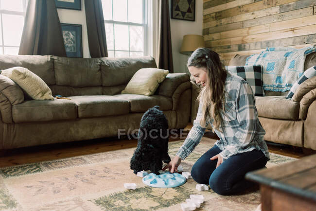 Jovem mulher passar o tempo e brincar com seu cachorro cão poodle preto — Fotografia de Stock