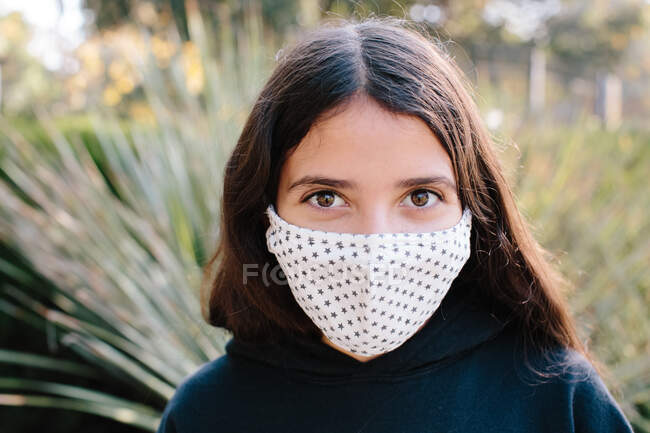 Retrato de uma menina Tween vestindo uma máscara facial de pano com um padrão de estrela — Fotografia de Stock