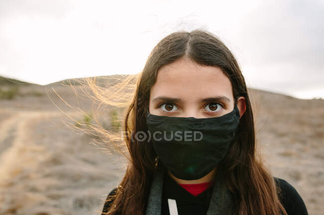 Intenso retrato de una chica adolescente fuera de usar un ventilador negro - foto de stock
