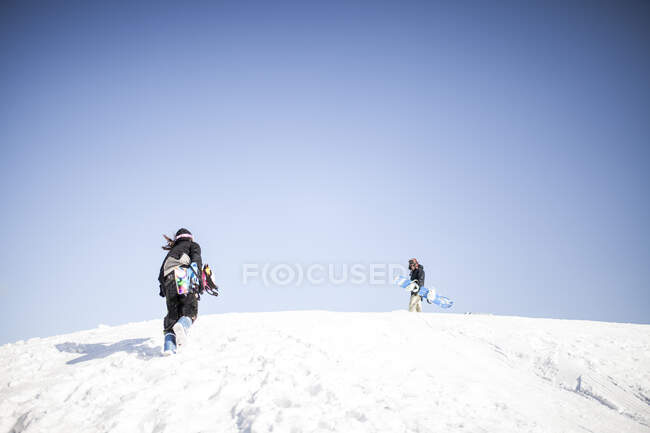 Dos chicos jóvenes haciendo snowboard juntos - foto de stock