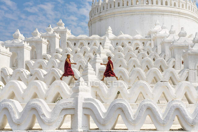 Due monaci alle prime armi che corrono e saltano a Hsinbyume pagoda, Mingun, Mandalay, Sagaing Township, Sagaing District, Sagaing Region, Myanmar — Foto stock
