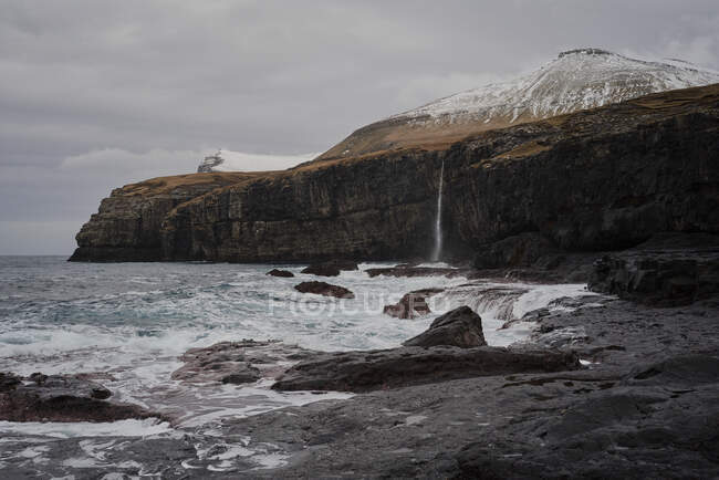 Cascada que desemboca en el océano en las Islas Feroe - foto de stock