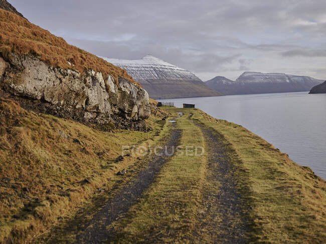 Strada sterrata lungo la baia nelle Isole Faroe — Foto stock