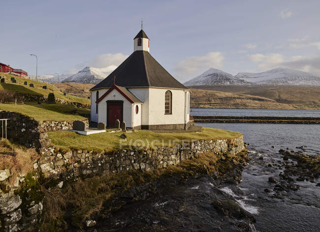 Igreja pequena pelo lago em montanhas — Fotografia de Stock