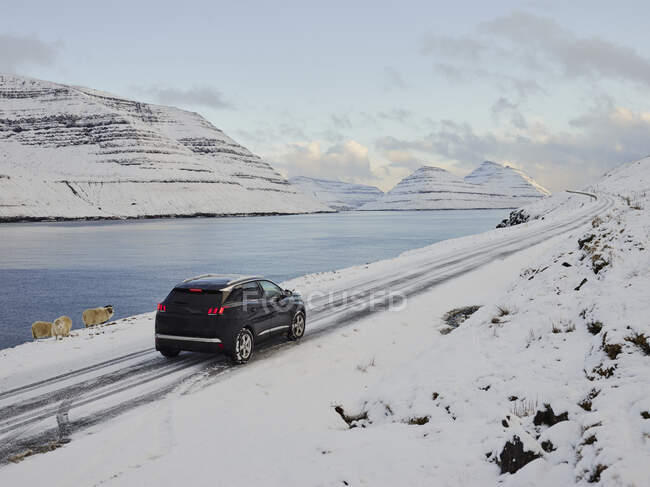 Auto sulla strada di montagna vicino al lago — Foto stock