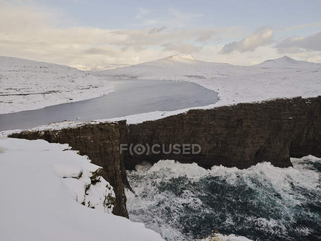 Ondas atingidas contra falésias perto do lago Leitisvatn nas Ilhas Faroé — Fotografia de Stock