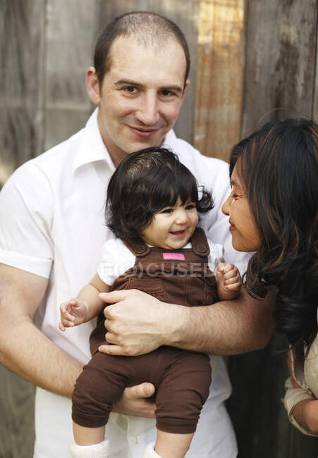 Father holding daughter while mother smiles at her — Stock Photo