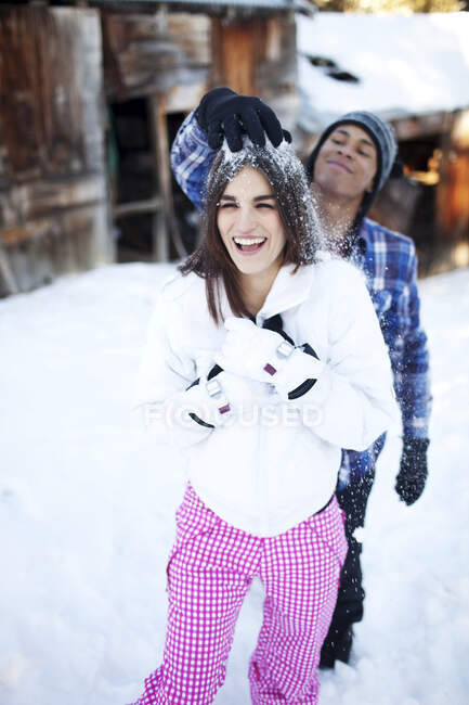 L'uomo getta scherzosamente la neve sulla testa della donna — Foto stock