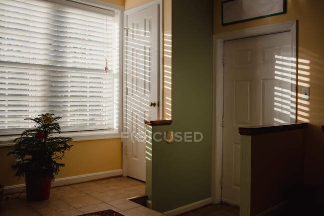 Luz solar brilhando através de persianas no interior doméstico — Fotografia de Stock