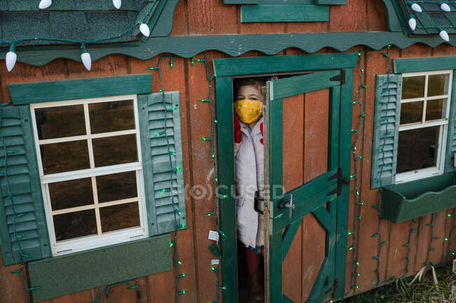 Jovem criança feminina em playhouse com luzes de Natal — Fotografia de Stock