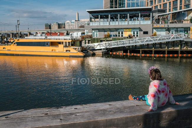 Young girl with tiara watching boats in river harbor — Stock Photo