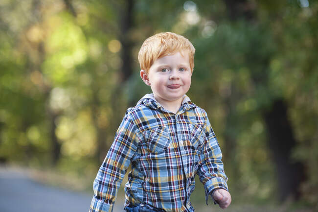 Gros plan de jeune garçon roux marchant avec la langue à l'extérieur — Photo de stock