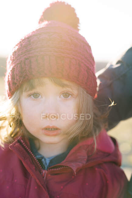 Portrait of toddler girl in pink hat and jacket during winter sunset — Stock Photo