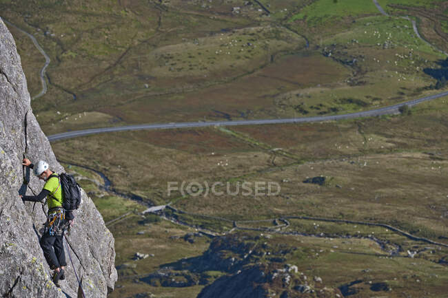 Homem escalando o rosto de rocha em Tryfan no norte do País de Gales — Fotografia de Stock