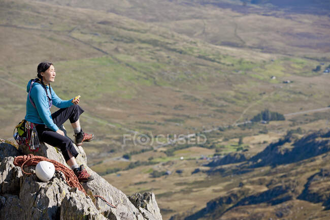 Female rock climber enjoying a sandwich on Tryfan in North Wales — Stock Photo